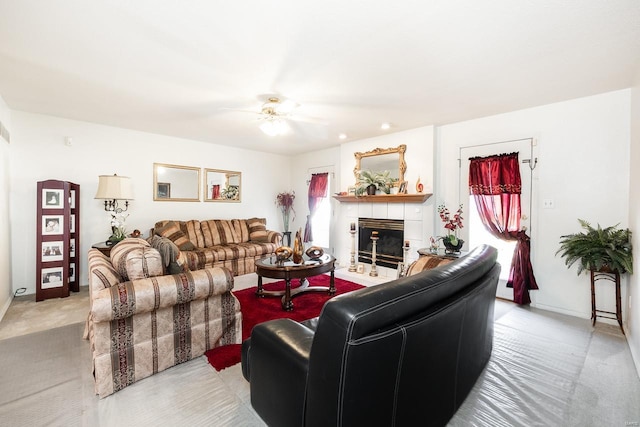 living room featuring a wealth of natural light, a tiled fireplace, light colored carpet, and ceiling fan