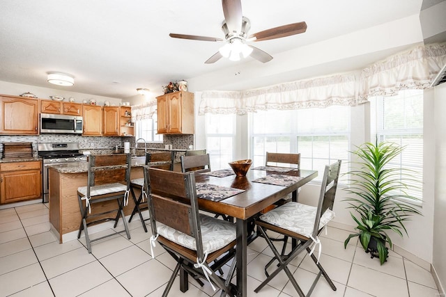 tiled dining space with plenty of natural light and ceiling fan