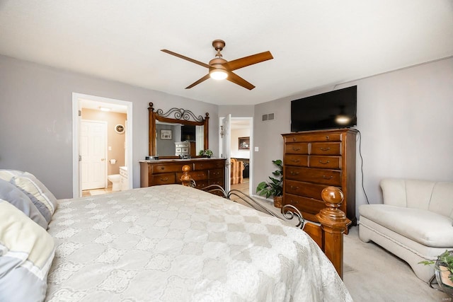 bedroom with light carpet, ensuite bathroom, and ceiling fan