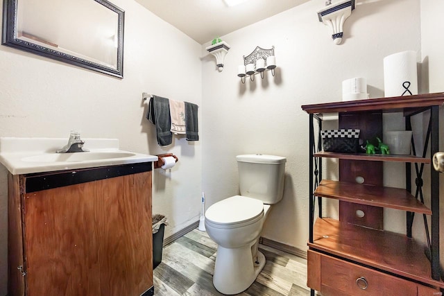 bathroom with vanity, toilet, and hardwood / wood-style floors