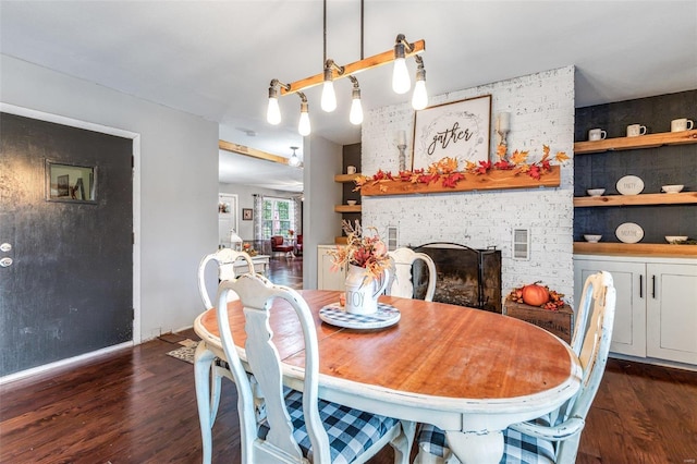 dining space with built in shelves, dark hardwood / wood-style flooring, and a brick fireplace