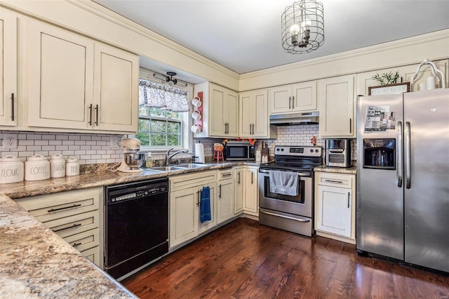 kitchen with appliances with stainless steel finishes, light stone counters, cream cabinets, and sink