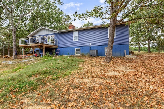 rear view of house featuring cooling unit and a wooden deck