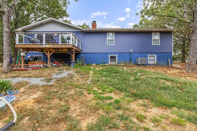 back of house featuring a yard, a wooden deck, and central air condition unit