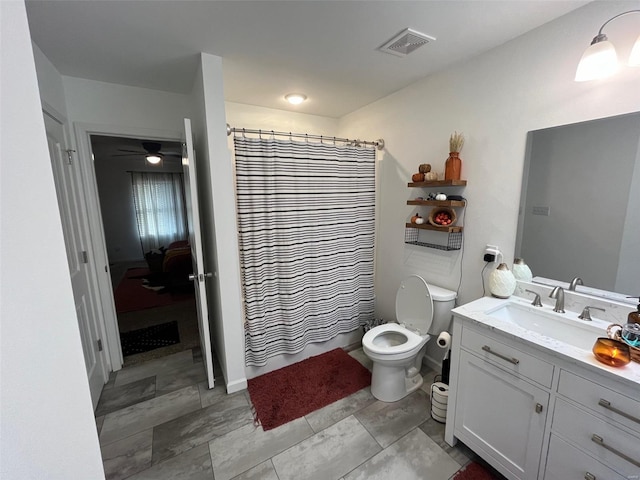 bathroom featuring curtained shower, toilet, and vanity