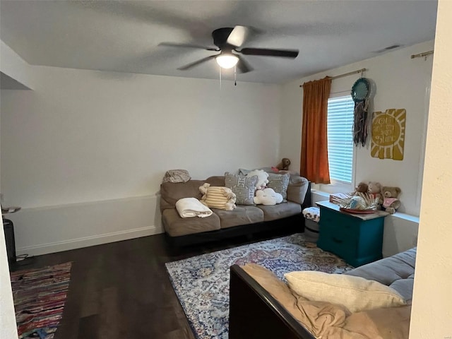 living room featuring ceiling fan and dark hardwood / wood-style flooring