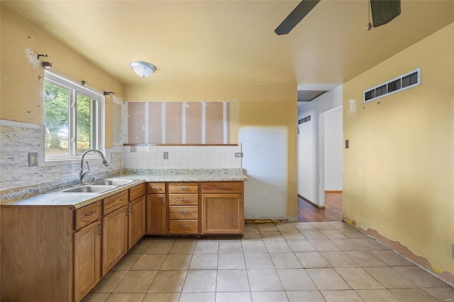 kitchen featuring sink, light tile patterned floors, and backsplash