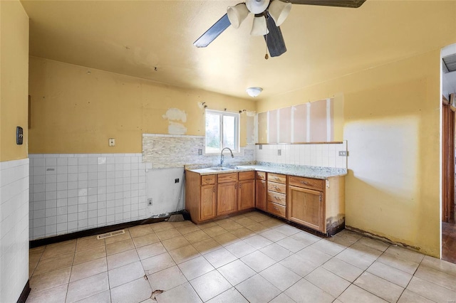 kitchen featuring sink, ceiling fan, tile walls, and light tile patterned floors