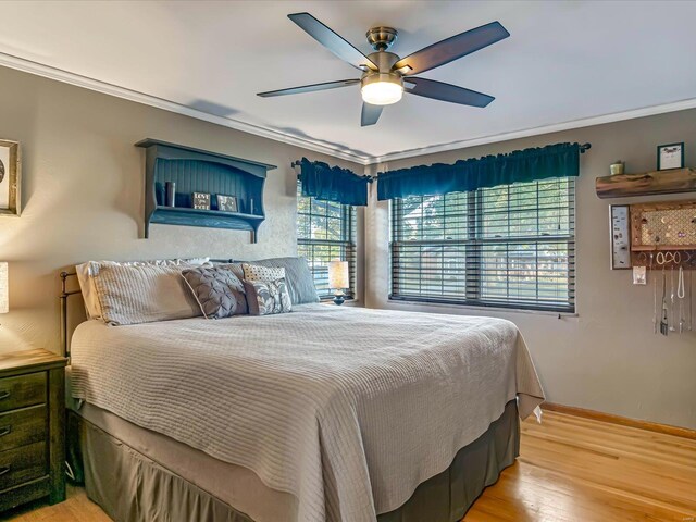 bedroom featuring ornamental molding, light wood-type flooring, and ceiling fan