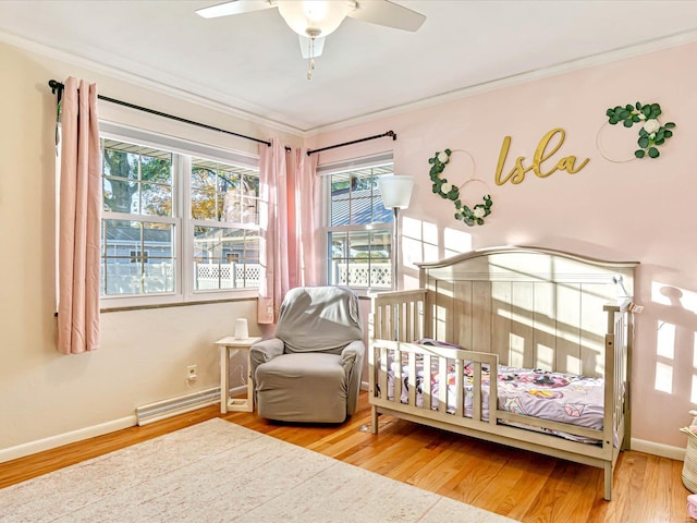 bedroom with hardwood / wood-style flooring, ceiling fan, and crown molding