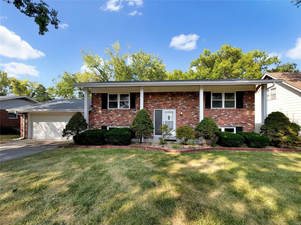 split foyer home with a garage and a front lawn