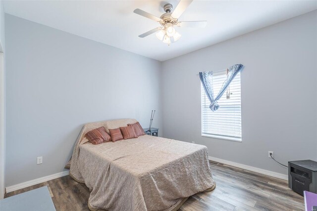 bedroom with ceiling fan and dark wood-type flooring