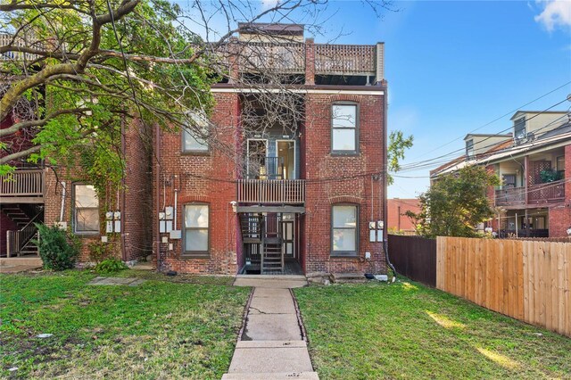 view of front of home with a balcony and a front lawn