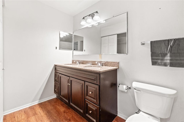 bathroom featuring vanity, hardwood / wood-style floors, and toilet