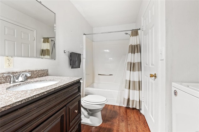 full bathroom featuring washer / clothes dryer, vanity, shower / bath combo, hardwood / wood-style flooring, and toilet