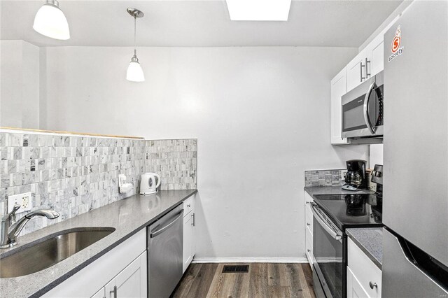 kitchen featuring pendant lighting, dark hardwood / wood-style floors, sink, white cabinets, and stainless steel appliances