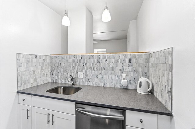 kitchen featuring pendant lighting, dishwasher, tasteful backsplash, sink, and white cabinets