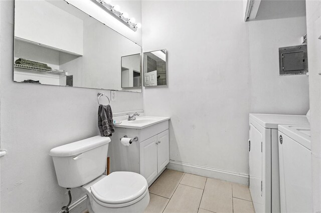 bathroom with vanity, electric panel, toilet, washing machine and dryer, and tile patterned flooring