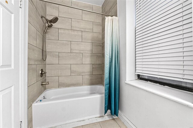 bathroom featuring shower / bath combo with shower curtain and tile patterned floors