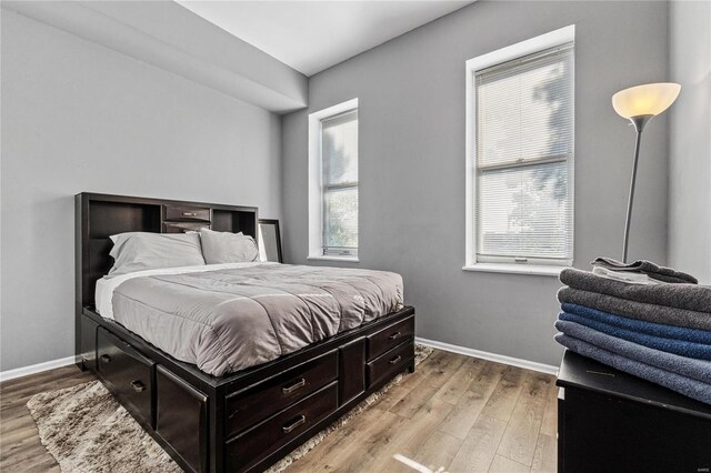 bedroom featuring multiple windows and light hardwood / wood-style flooring