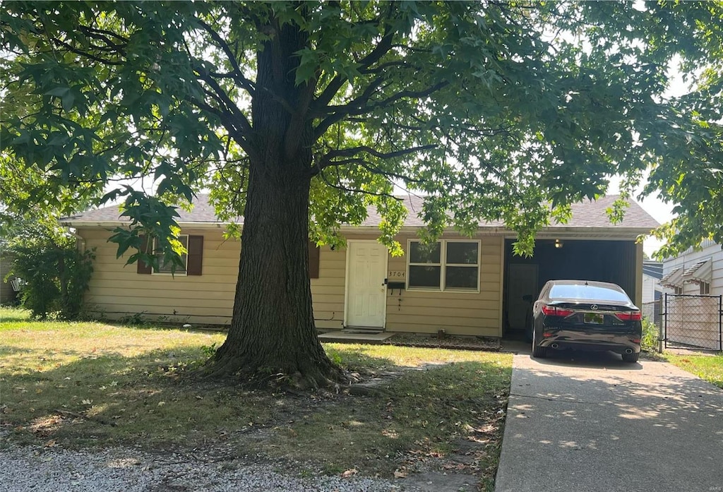 ranch-style home with a garage and a front lawn