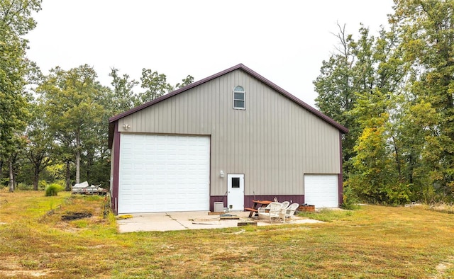 exterior space with a yard, a garage, and an outbuilding