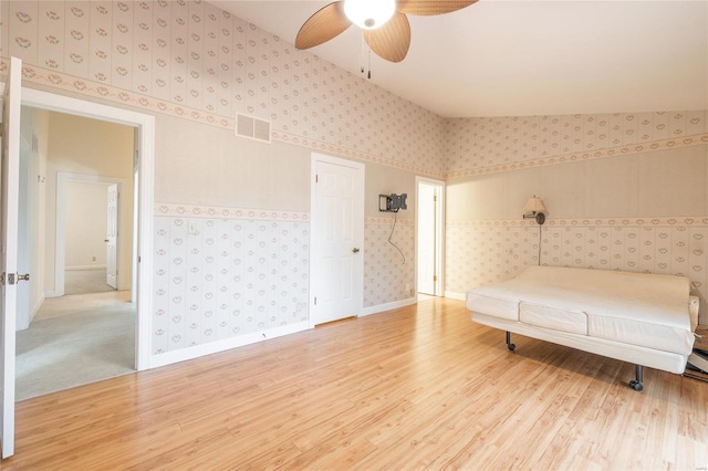 unfurnished bedroom with ceiling fan, wood-type flooring, and vaulted ceiling