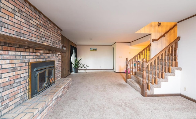 unfurnished living room featuring a fireplace, crown molding, and carpet