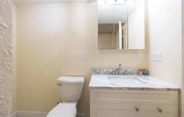 bathroom featuring toilet, baseboards, and vanity