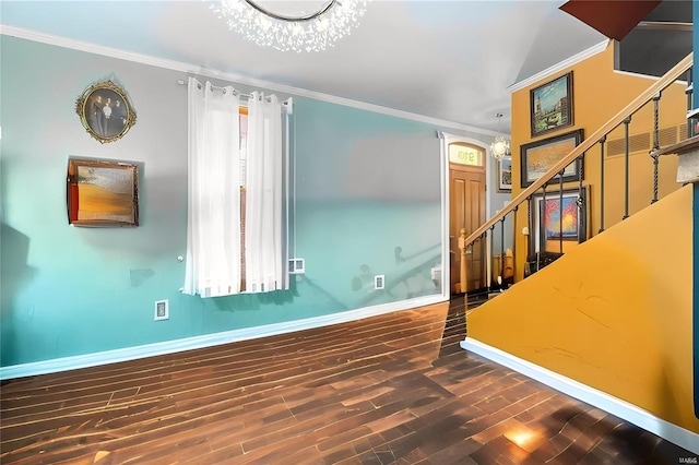 interior space featuring dark hardwood / wood-style floors, ornamental molding, and an inviting chandelier