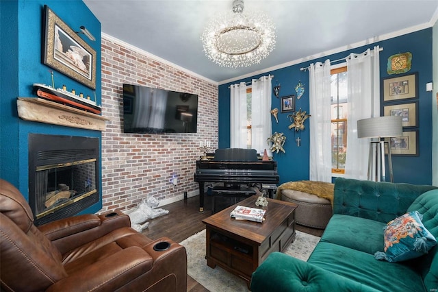 living room with a notable chandelier, wood-type flooring, ornamental molding, and brick wall