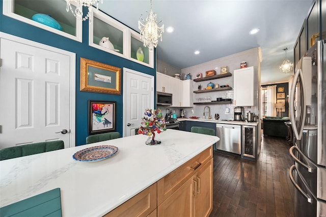 kitchen featuring decorative backsplash, appliances with stainless steel finishes, dark wood-type flooring, pendant lighting, and white cabinetry