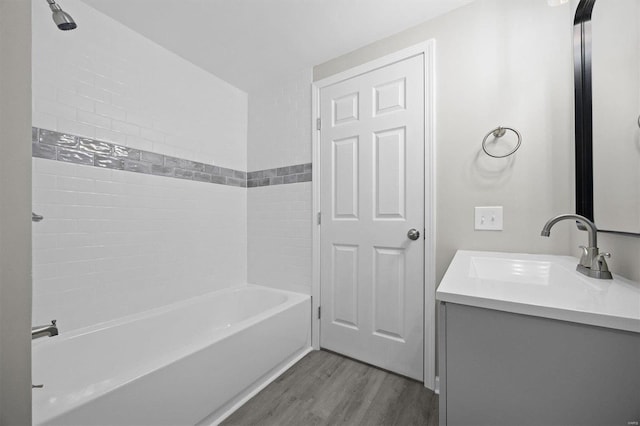 bathroom featuring vanity, tiled shower / bath, and hardwood / wood-style flooring