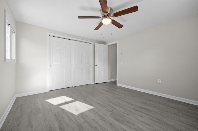 unfurnished bedroom with ceiling fan, a closet, and hardwood / wood-style flooring