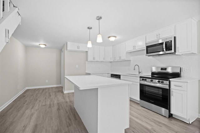 kitchen with a center island, hanging light fixtures, appliances with stainless steel finishes, and white cabinetry