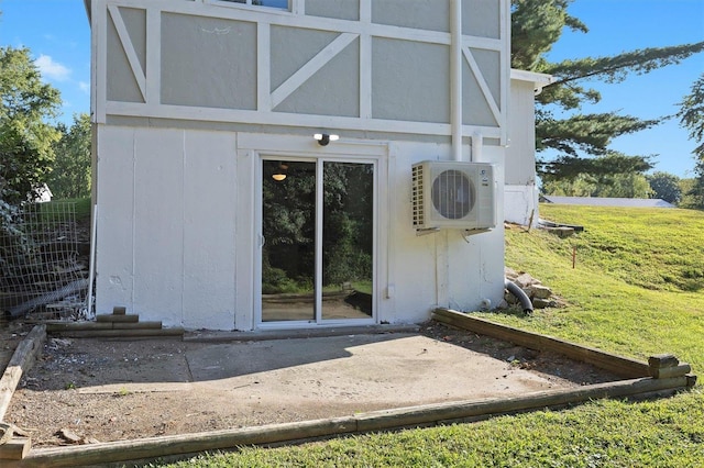 entrance to property featuring a lawn and ac unit