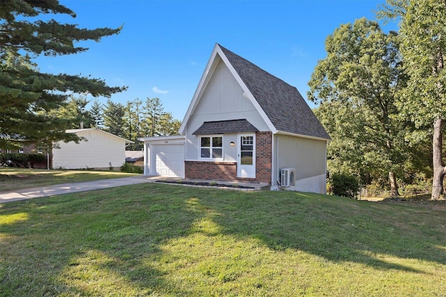 view of front of property featuring a garage, a front lawn, and an outbuilding