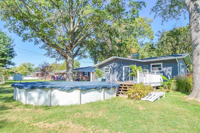 view of pool with a deck and a yard