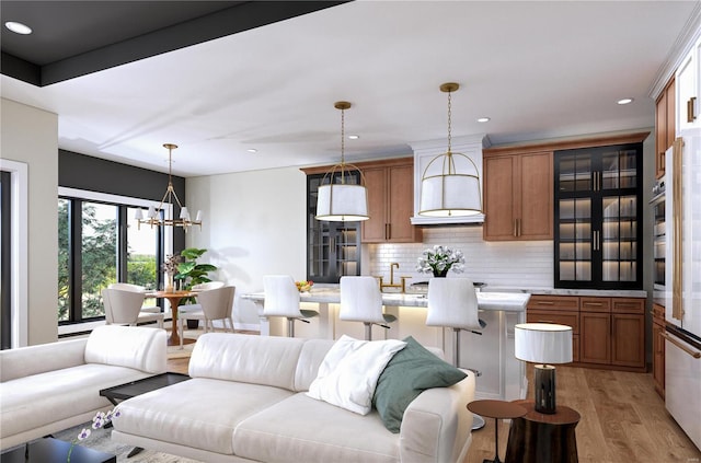 living room with light wood-type flooring, sink, and a chandelier