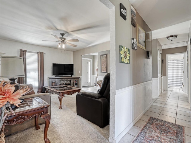 tiled living room with a fireplace and ceiling fan