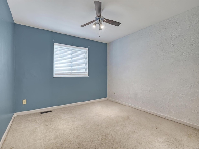 unfurnished room with ceiling fan and carpet floors