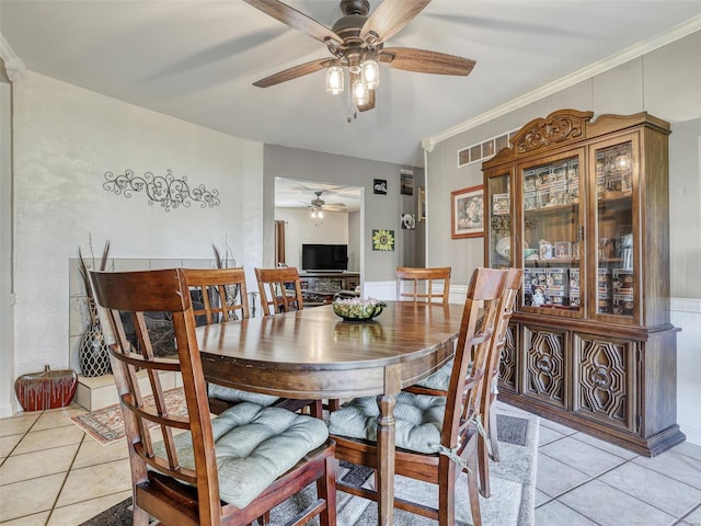 dining area featuring crown molding, light tile patterned floors, and ceiling fan