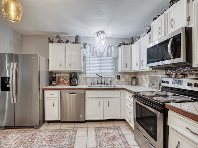 kitchen with appliances with stainless steel finishes, sink, and white cabinetry