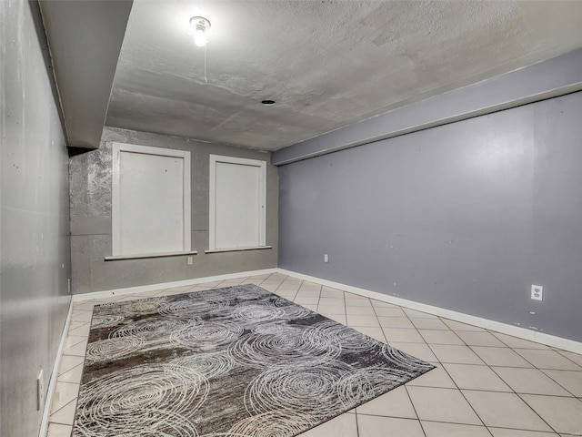 tiled spare room featuring a textured ceiling