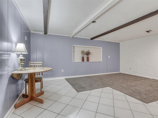 interior space featuring wooden walls, beamed ceiling, and light tile patterned floors