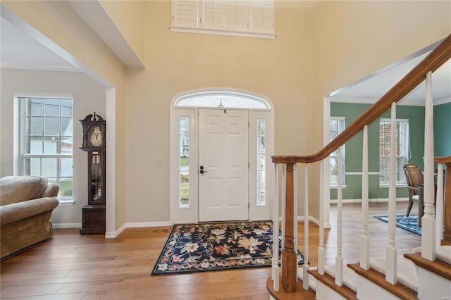 entrance foyer featuring ornamental molding and light hardwood / wood-style floors