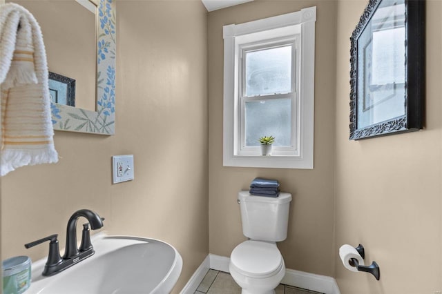 bathroom featuring toilet, sink, and tile patterned floors