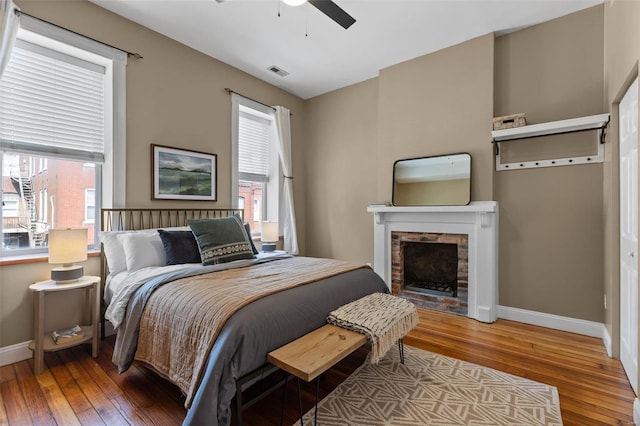 bedroom featuring ceiling fan, wood-type flooring, and multiple windows