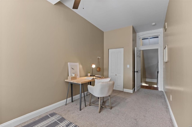 office space featuring lofted ceiling, ceiling fan, and light colored carpet