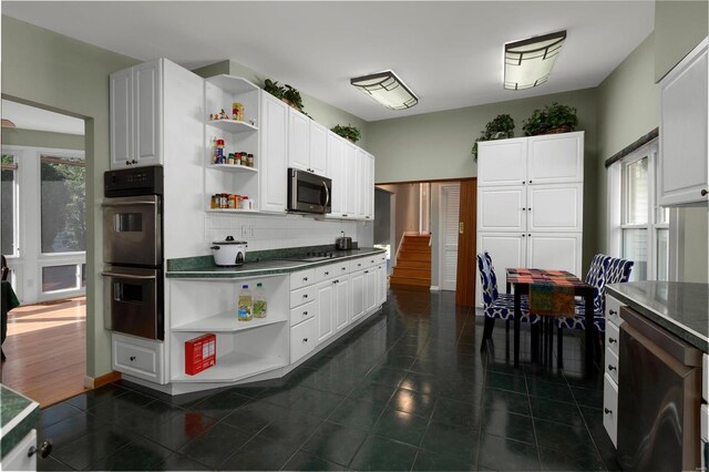 kitchen featuring black appliances, white cabinets, decorative backsplash, and a wealth of natural light